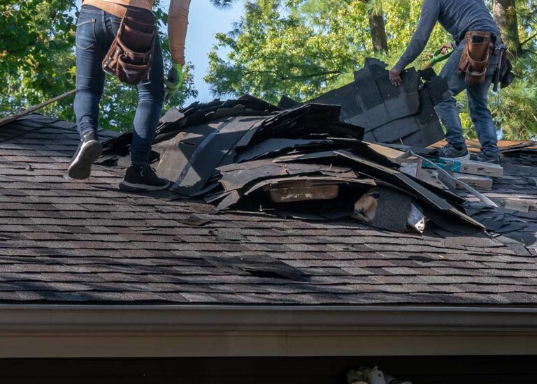 A person standing safely on the ground uses binoculars to inspect roof stains and discoloration after recent rain.